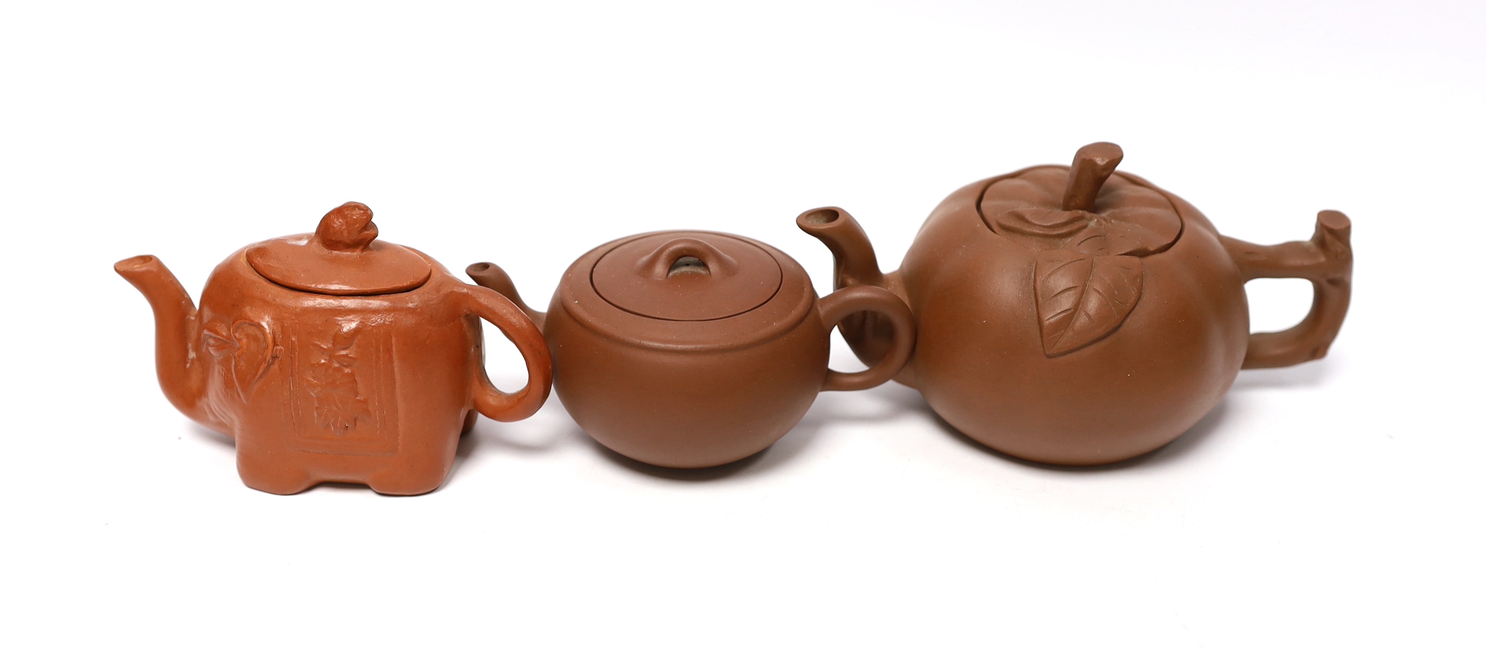 Eleven Chinese items including four Yixing pottery teapots, a stone disc, a jade horse and five miniature bowls, tallest teapot 6.5cm